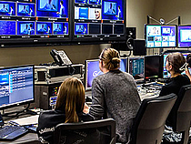 Fünf Studierende sitzen in der Regie des Fernsehstudios und schauen auf Bildschirme