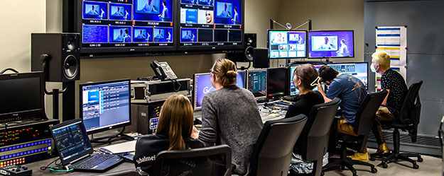 Fünf Studierende sitzen in der Regie des Fernsehstudios und schauen auf Bildschirme